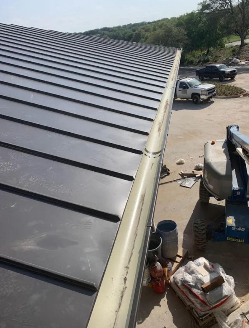 Standing seam panel and gutter detail on a metal roofing jobsite in Lynnfield